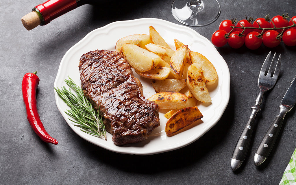 Steak grillé sauce au poivre sur le barbecue et asperges